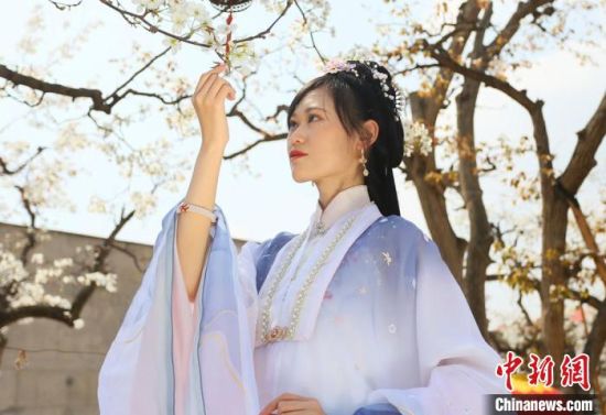 圖為蘭州青年身穿漢服在百年梨園賞景?！「哒?攝