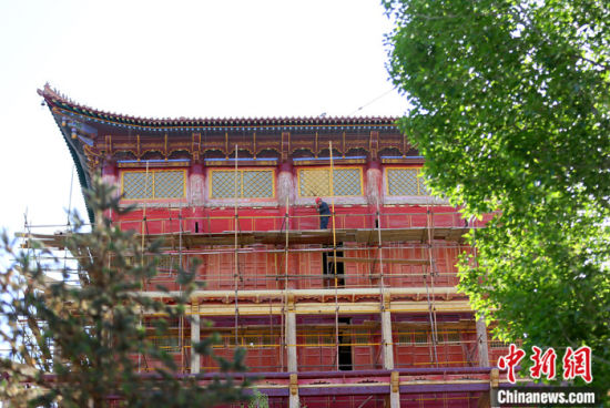 圖為5月上旬，甘肅山丹縣大佛寺內(nèi)，工作人員對(duì)古建筑大雄寶殿進(jìn)行修繕。 中新社記者 高展 攝