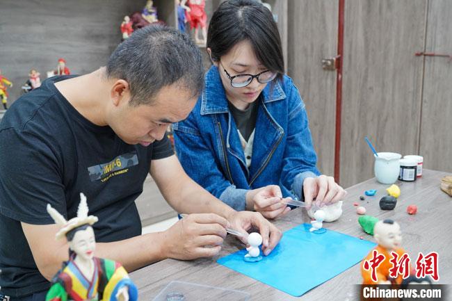 <a target='_blank'  data-cke-saved- >中新社</a>記者(右)現(xiàn)場(chǎng)體驗(yàn)面塑制作過程?！￡悹?zhēng)強(qiáng) 攝