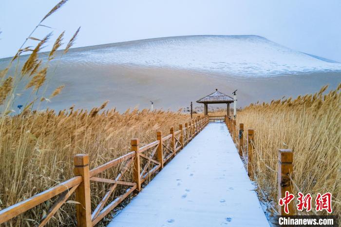 2021年11月28日，在敦煌鳴沙山月牙泉景區(qū)，沙雪交融，更顯北國風情?！⊥醣筱y 攝
