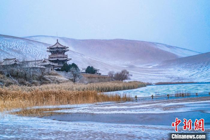 2021年11月28日，雪落鳴沙山月牙泉景區(qū)。　王斌銀 攝