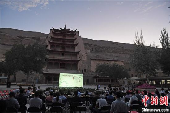 2018年8月，在敦煌莫高窟標(biāo)志性建筑“九層樓”前，《回顧平山郁夫先生的貢獻(xiàn)》座談會(huì)舉行。來自中日兩國的專家、學(xué)者共同懷念這位情系敦煌數(shù)十載的繪畫巨匠、中日友好的文化使者、世界文化遺產(chǎn)的守護(hù)者。中新社記者 楊艷敏 攝