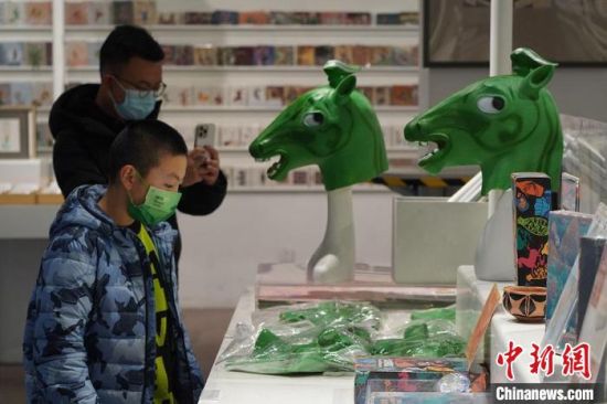 圖為“神馬來了”銅奔馬頭套吸引參觀者駐足?！【琶赖┰?攝