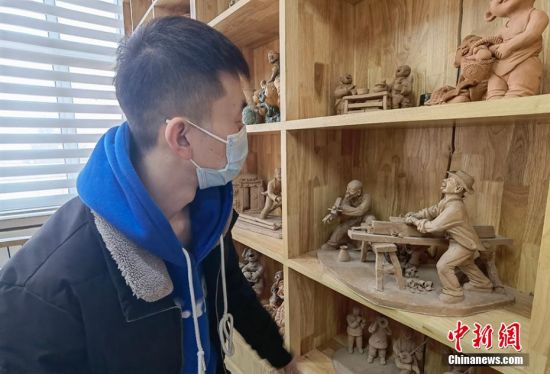 圖為學(xué)生欣賞泥塑作品。 劉玉桃 攝