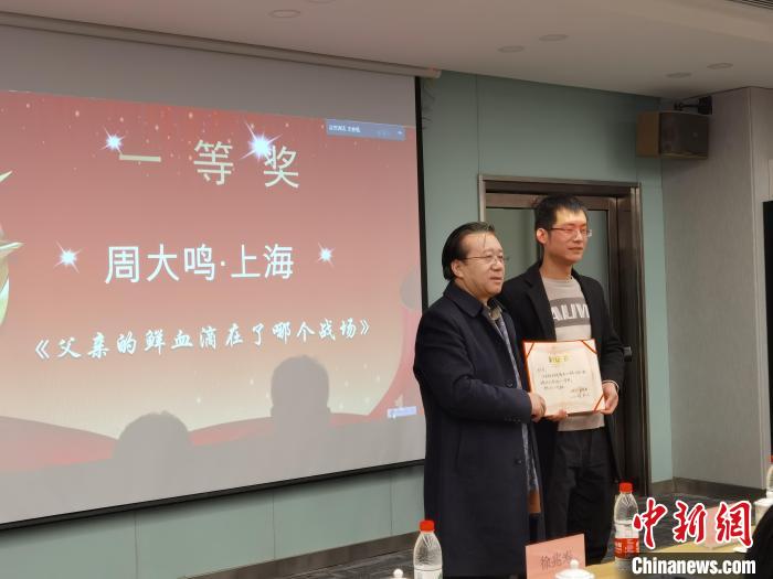 圖為作家、西北師范大學(xué)新聞與傳媒學(xué)院院長徐兆壽頒發(fā)一等獎(jiǎng)證書，代領(lǐng)獎(jiǎng)?wù)呱吓_(tái)領(lǐng)獎(jiǎng)?！钅?攝