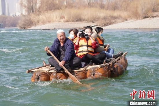 2月24日，年過(guò)七旬的蘭州羊皮筏子制作技藝第三代傳承人張德寶在黃河上劃著羊皮筏子。(資料圖) 九美旦增 攝