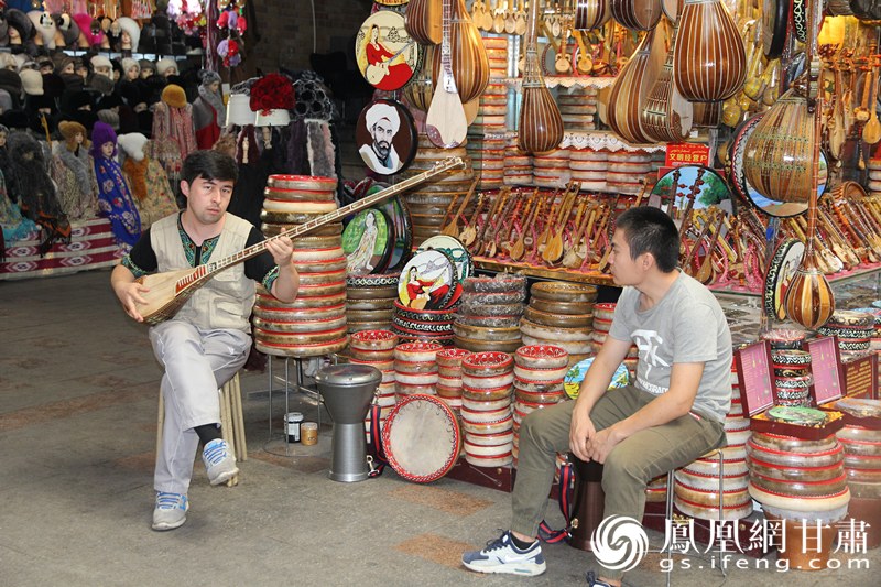 烏魯木齊二道橋巴扎內(nèi)，店主正在向客人展示樂器。楊文遠(yuǎn) 攝