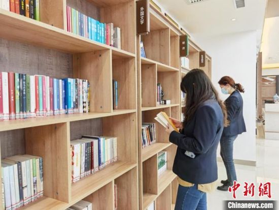 圖為在甘肅公航旅建設(shè)集團(tuán)有限公司的職工書屋，職工挑選書籍。　徐雪 攝