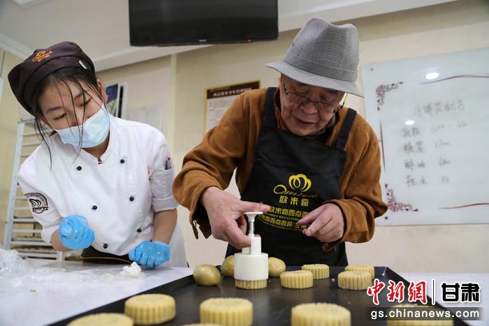 當(dāng)日，受邀參加活動(dòng)的臺(tái)胞臺(tái)屬代表、兩岸婚姻及子女、在甘臺(tái)商代表等歡聚一堂。圖為77歲的在甘臺(tái)胞潘天鑒制作月餅。九美旦增 攝