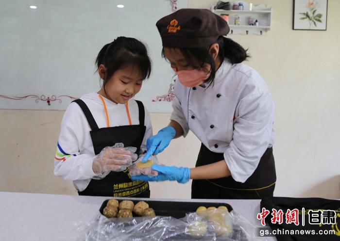 圖為在甘臺(tái)胞小朋友在工作人員指導(dǎo)下制作月餅。九美旦增 攝