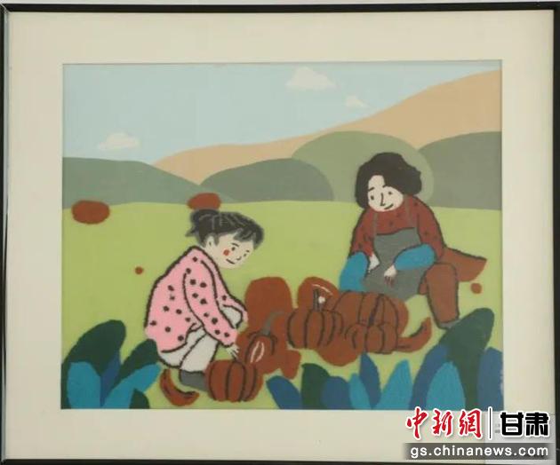 嘉峪關(guān)市新城鎮(zhèn)新城村農(nóng)業(yè)產(chǎn)業(yè)園區(qū)內(nèi)，母女兩人在摘南瓜。刺繡 馬艾米乃 繡稿 敬紅霞