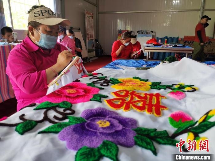 圖為婦女制作青繡?！?zhí)砀?攝
