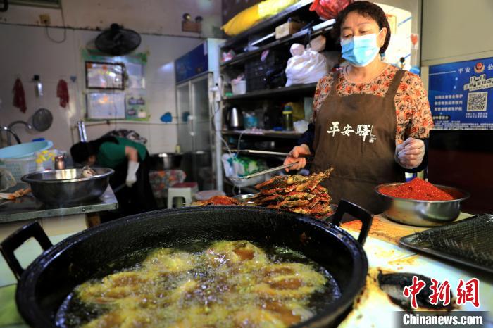 圖為平安驛·河湟民俗文化體驗(yàn)地內(nèi)的商戶(hù)炸干板魚(yú)?！⊙Φ?攝