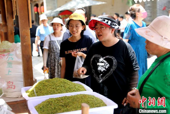 圖為民眾購(gòu)買(mǎi)青海特色小吃?！⊙Φ?攝