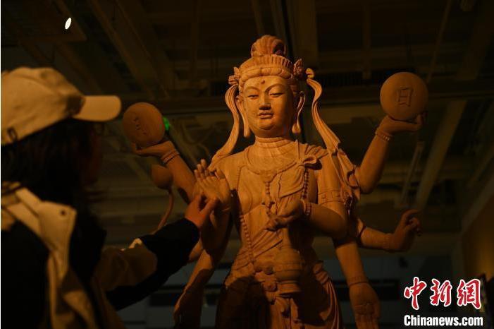 圖為季茂杰觀(guān)察自己創(chuàng)作的敦煌木雕。李亞龍 攝</p>
<p>