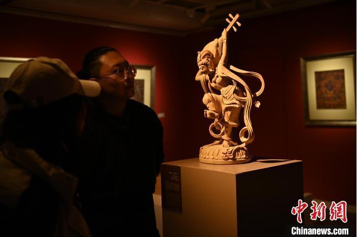 圖為季茂杰向參觀(guān)者介紹自己創(chuàng)作敦煌木雕的過(guò)程。李亞龍 攝</p>
<p>