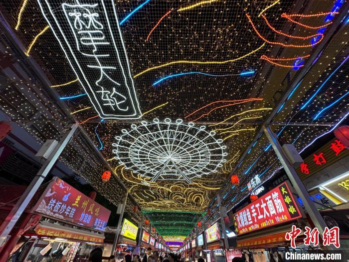 圖為明清街夜市燈光點(diǎn)亮具有武威文化元素的“摩天輪”彩燈。　戴文昌 攝</p><p>