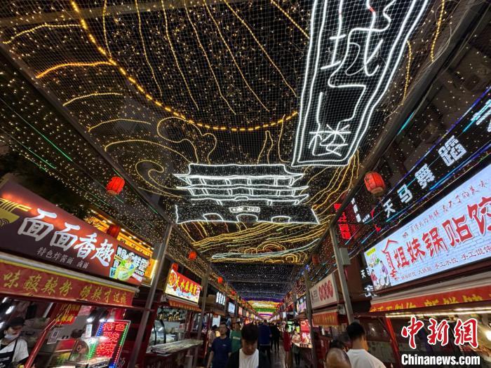 圖為明清街夜市燈光點(diǎn)亮具有武威文化元素的“涼州古城門”彩燈?！〈魑牟?攝</p><p>